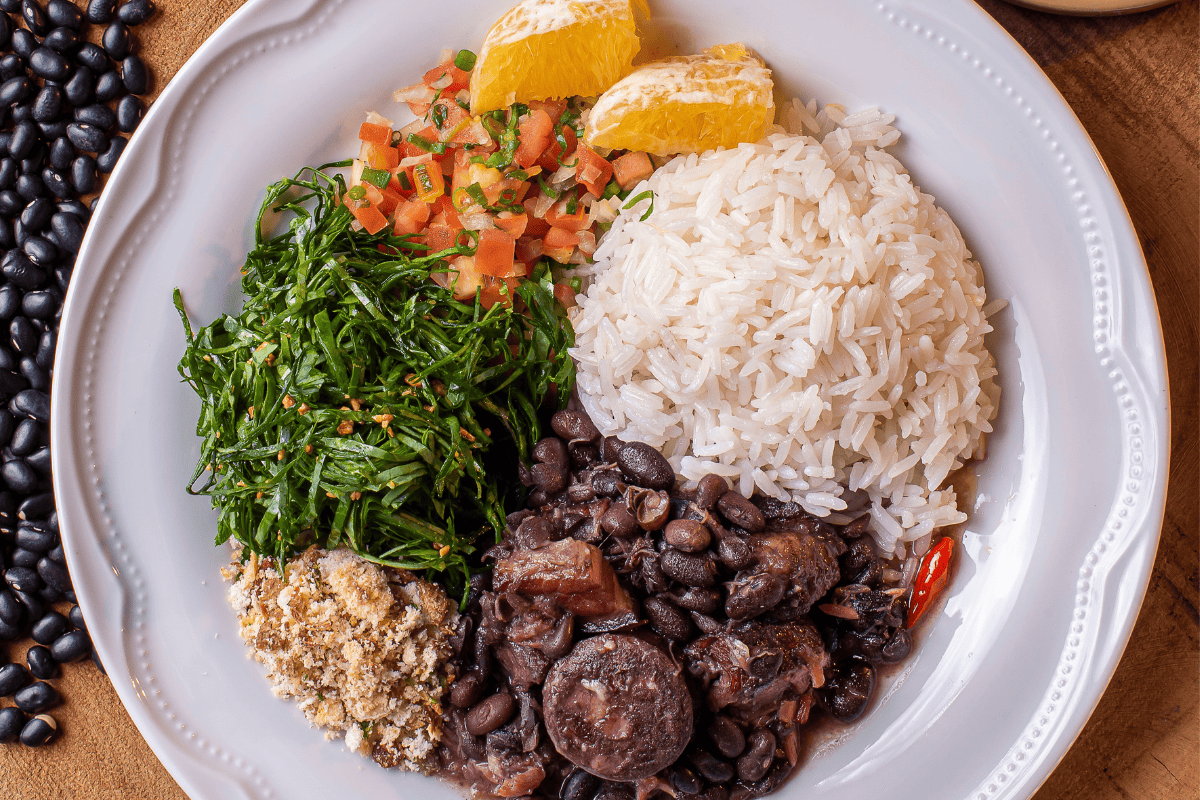 Brazilian rice with feijoada, collards, and orange slices