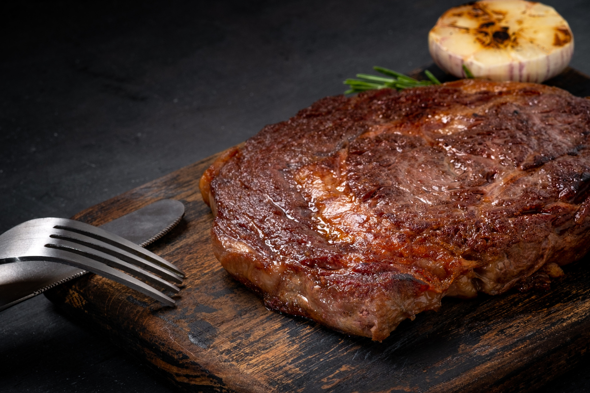 Pernil de cerdo on a cutting board with roast garlic