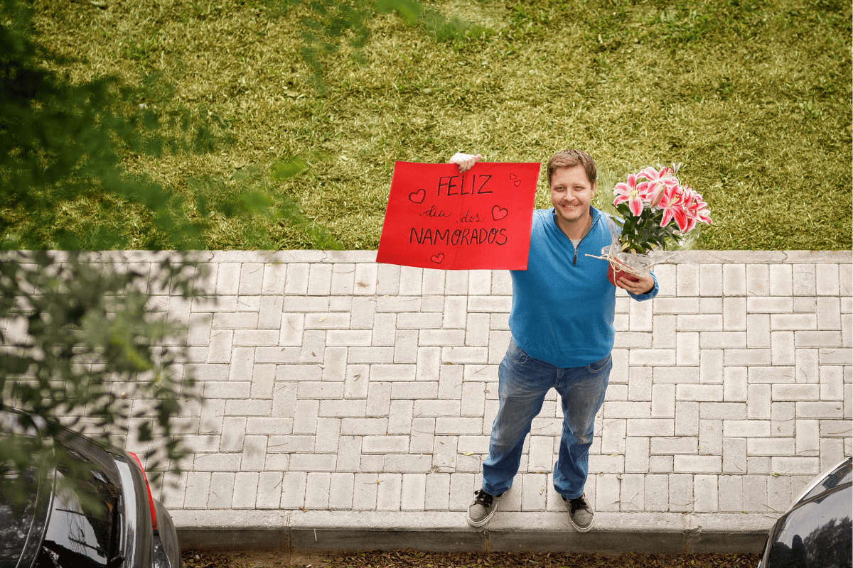 man with sign that says "happy valentine's day" in Portuguese
