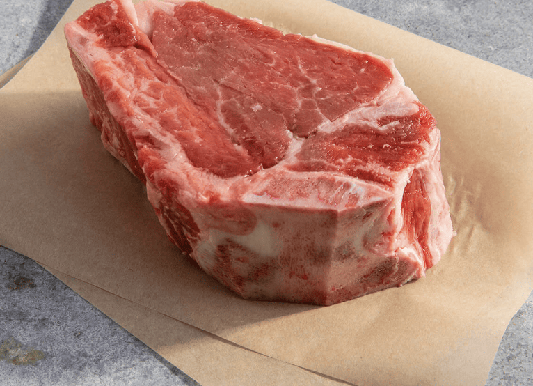raw cut of bone in filet mignon on butcher paper